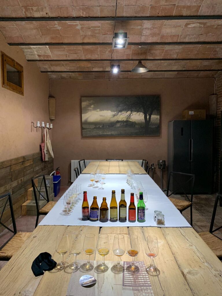 Tast de Cerveses 22 Sala de catas con botellas de cerveza artesana y copas servidas sobre mesa rústica en masia de Barcelona
