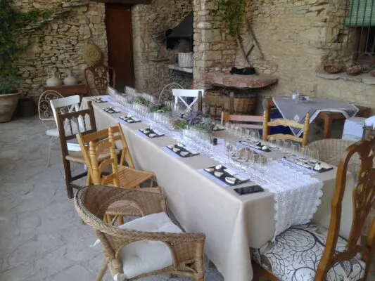 Mesa de cata preparada en patio de piedra exterior de masía rural con copas y pizarras individuales