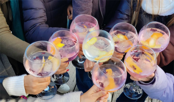 Grupo brindando con copas balloon de gin tonic en taller de destilados en Barcelona