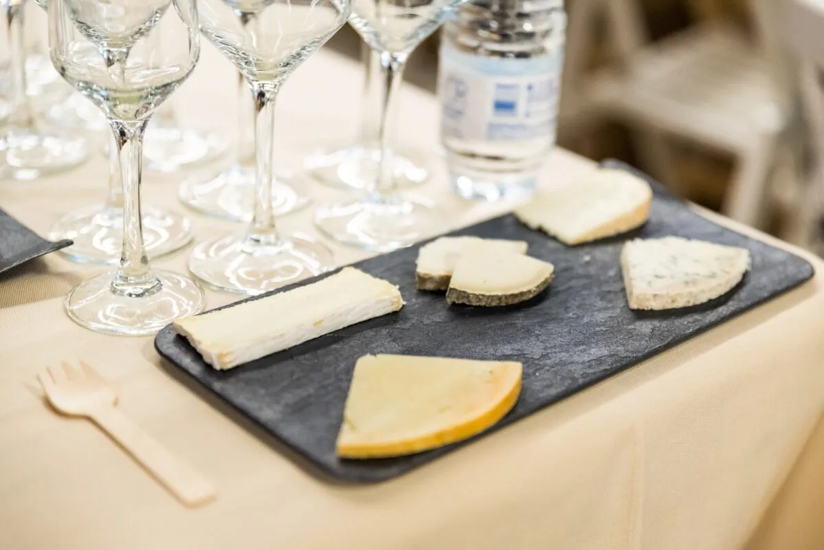 Pizarra con cuatro tipos de queso distintos preparados para cata de vinos y quesos en Barcelona