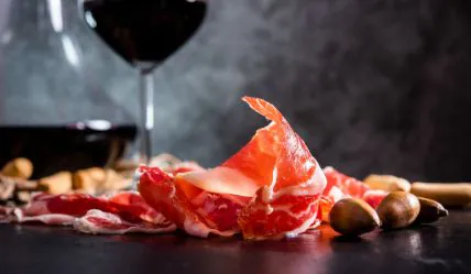 Tast de Pernils 1 Lonchas de jamón ibérico con copa de vino tinto y bellotas en cata de maridaje en Barcelona